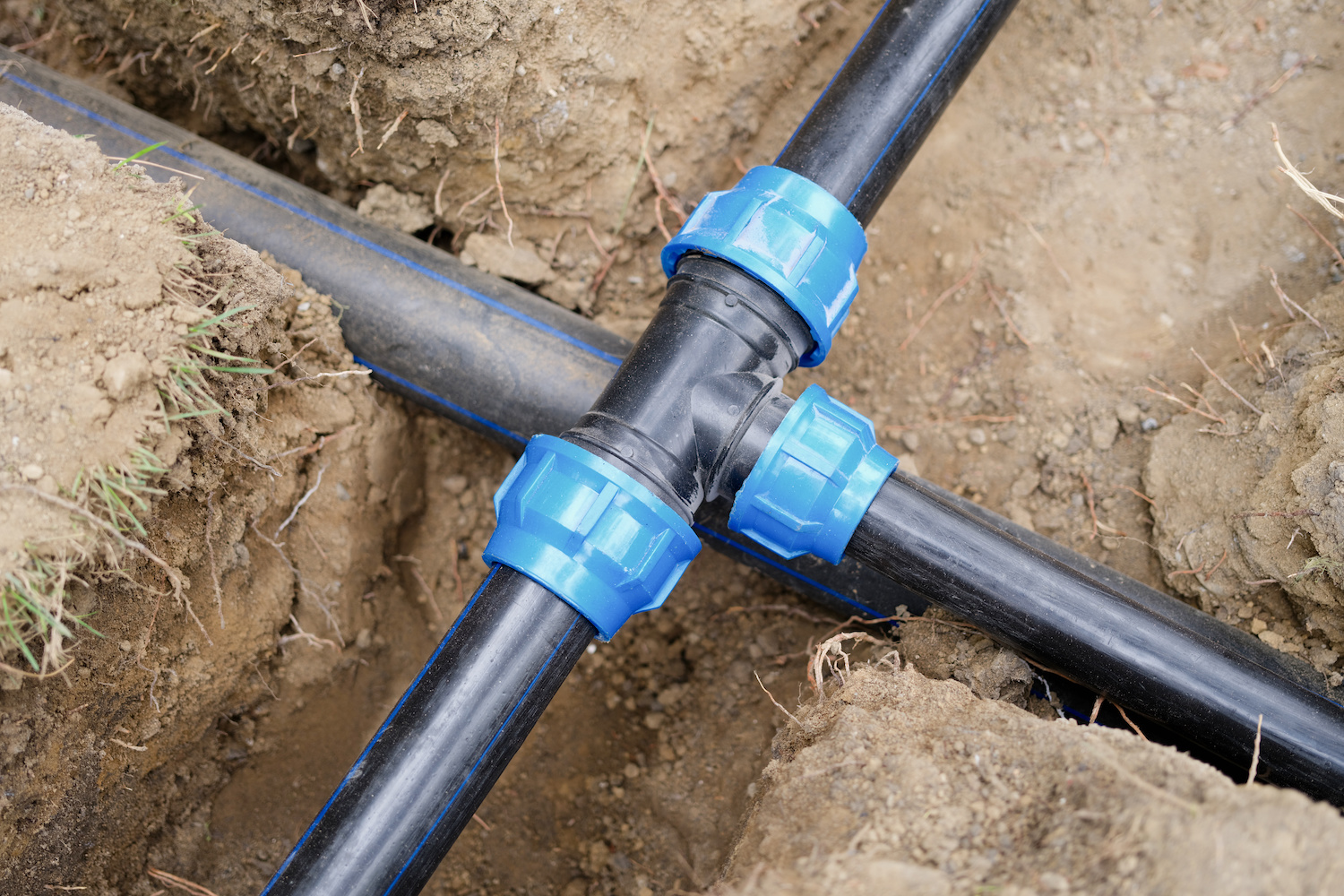 Installed PVC water pipes in trench at construction site. Plumbing system outside the house concept