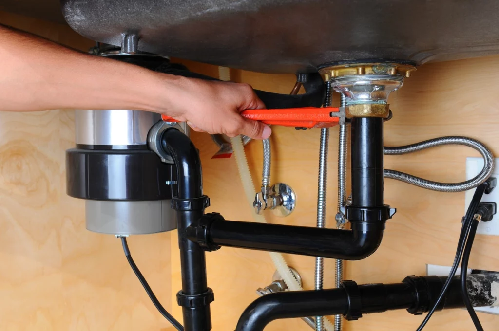 plumber installs garbage disposal using best tools