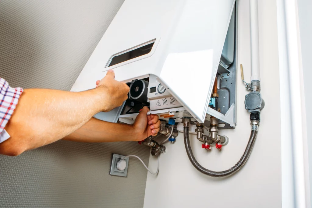plumber works on gas boiler at home