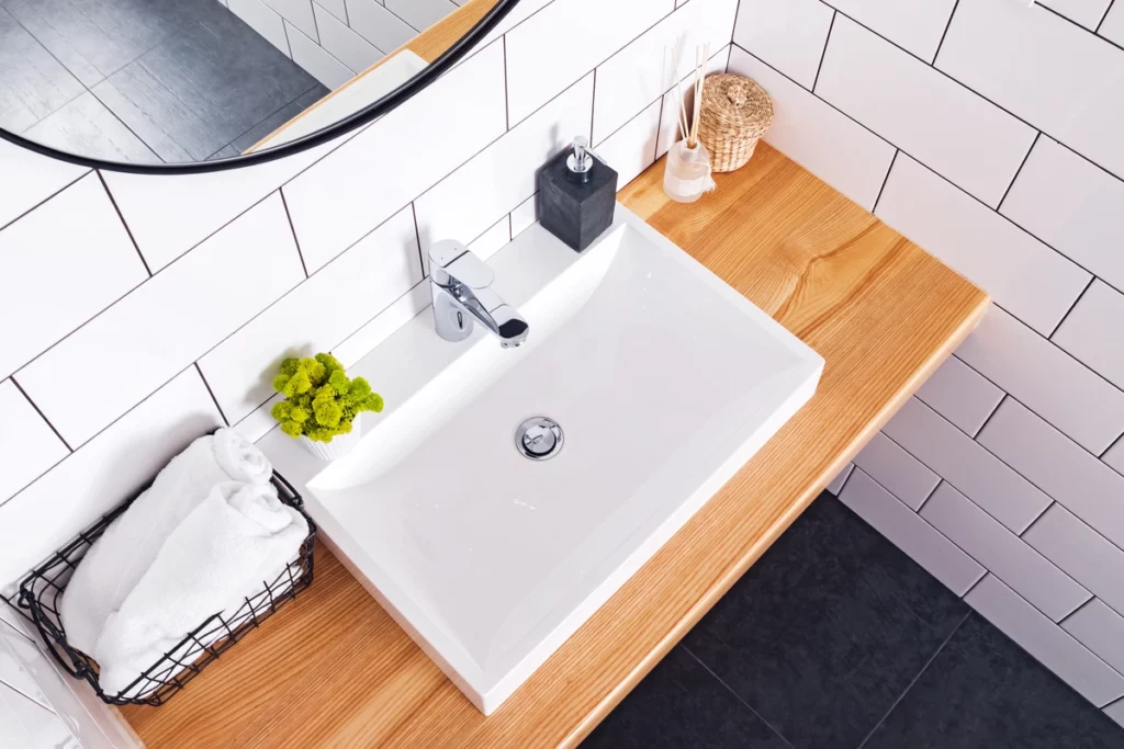 modern bathroom with a sink on wood countertop after renovating bathroom