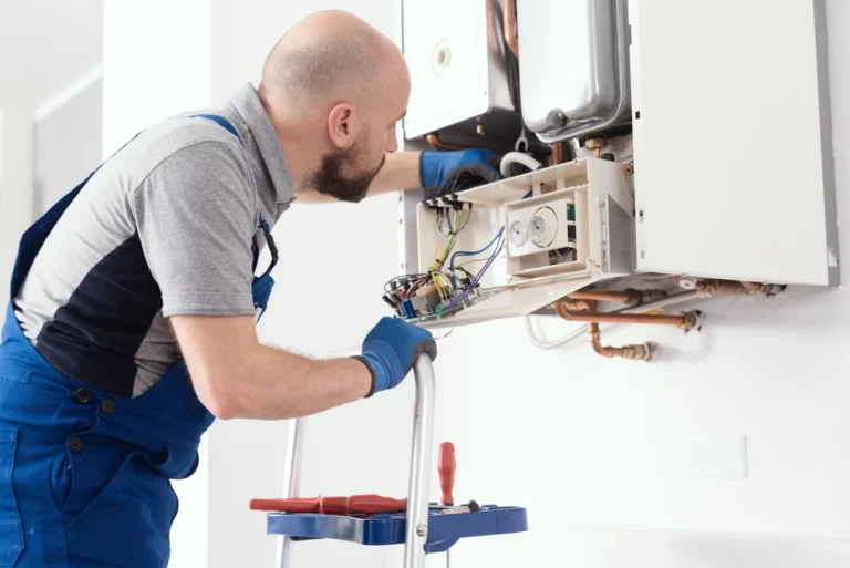 Service technician repairing water heater on the wall