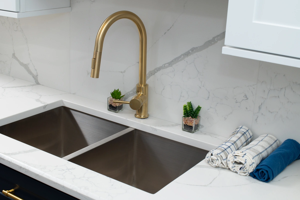 stainless steel faucet with a white backsplash
