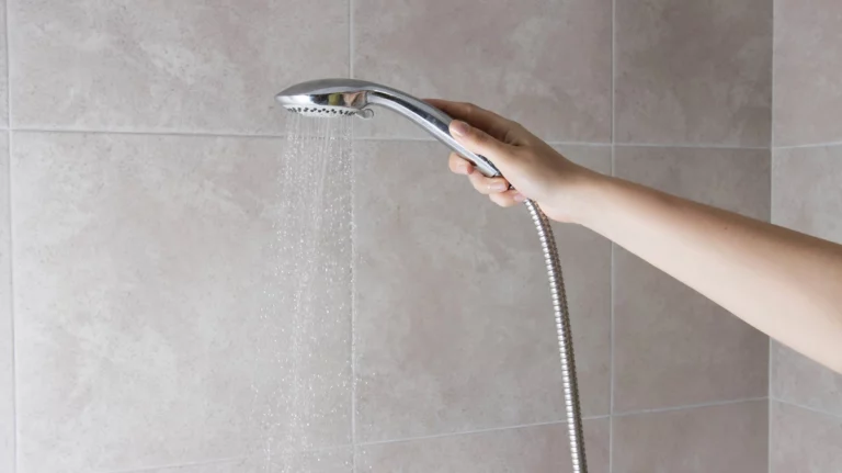 woman holding the shower head with high water pressure